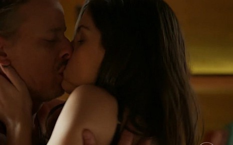 Vavá (Marcelo Novaes) beija Duda (Giselle Batista) em cena de A Regra do Jogo - Reprodução/TV Globo