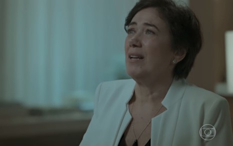 A atriz Lilia Cabral, de blazer branco, chora em cena como Silvana em A Força do Querer
