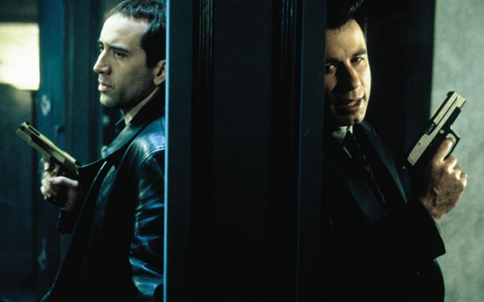 Nicolas Cage e John Travolta separados por uma parede com armas na mão em A Outra Face