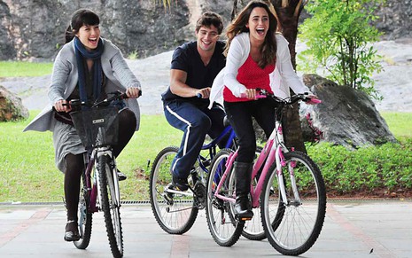 Os atores Marjorie Estiano, Rafael Cardoso e Fernando Vasconcellos sorriem e andam de bicicleta em cena de A Vida da Gente