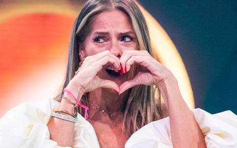 A apresentadora Adriane Galisteu faz sinal de coração com as mãos durante gravação do quadro Gonga La Gonga, do Caldeirão do Huck (Globo)