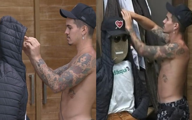 Biel aparece em pé, ao lado do boneco criado pelos participantes da casa; o peão está de boné e sem camiseta; o boneco usa jaqueta preta, camiseta branca e calça laranja, além de óculos escuro