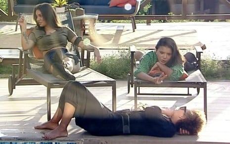 Stéfani Bays (à esq.), Jakelyne Oliveira (à dir.) e Lidi Lisboa (deitada) curtem sol na beira da piscina em A Fazenda 12