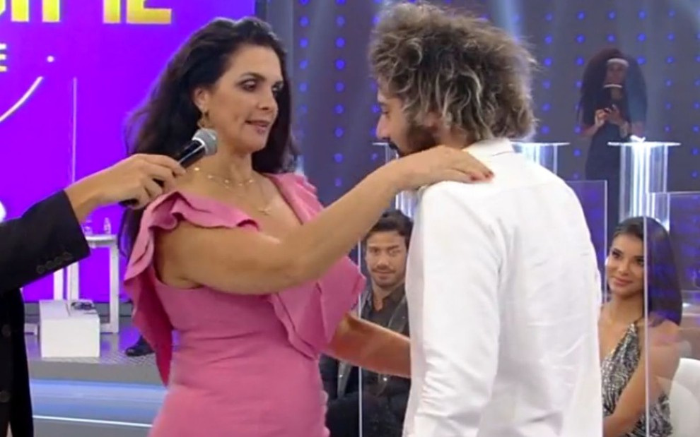 Imagem de Luiza Ambiel abraçando Cartolouco no palco do Hora do Faro