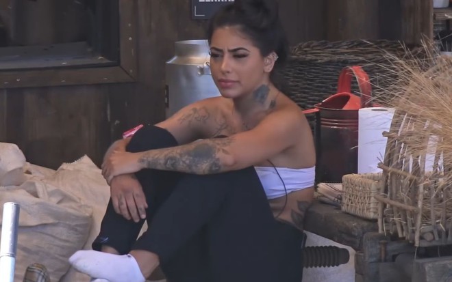 MC Mirella sentada na área externa da sede de A Fazenda 12