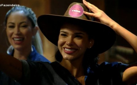 Jakelyne Oliveira sorridente com o chapéu de fazendeira