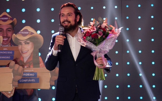 Imagem de Lucas Strabko, o Cartolouco, com buquê de flores na mão