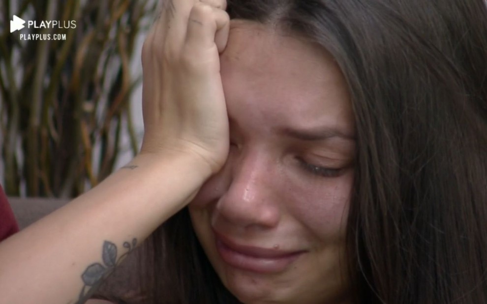 Imagem de Stéfani Bays com a mão no rosto enquanto chora em A Fazenda 12
