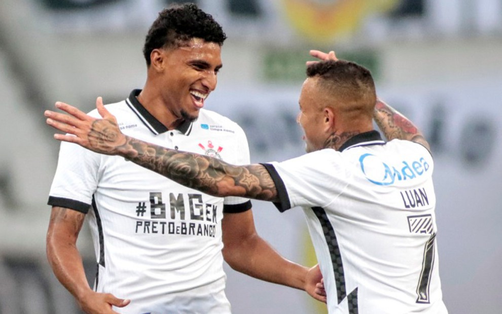 Vestindo a camisa 7 do Corinthians, o jogador Luan abre os braços para abraçar o Éderson em jogo do Paulistão 2020