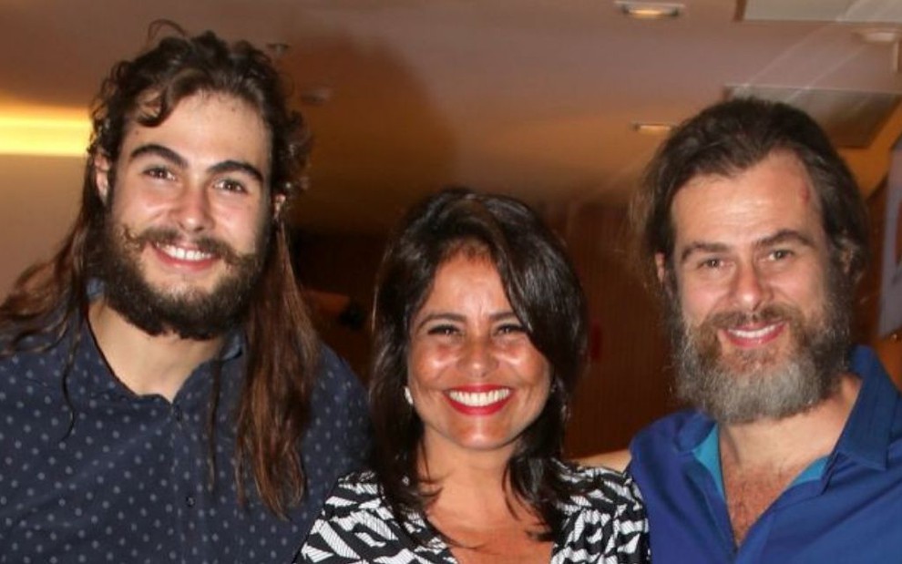 Foto do ator Rafa Vitti (à esquerda) com os pais, Valéria Alencar Vitti (ao centro) e João Vitti (à direita), durante um evento social; os três aparecem sorrindo e abraçados lado a lado
