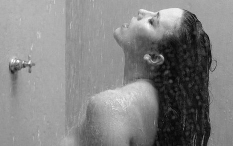 Foto preto e branco de Alice Wegmann sem roupa, tomando banho, com um coração cobrindo o mamilo