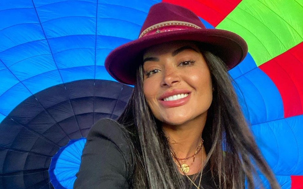 Atriz Aline Riscado em foto publicada no Instagram com fundo colorido