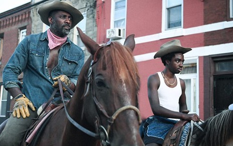 Idris Elba e Caleb McLaughlin em cena de Alma de Cowboy