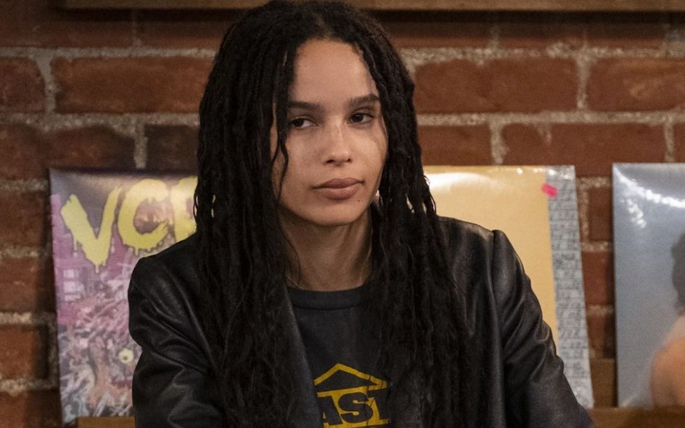 Com cabelo trançado bem comprido, Zoë Kravitz fecha o semblante dentro de uma loja de discos em Alta Fidelidade