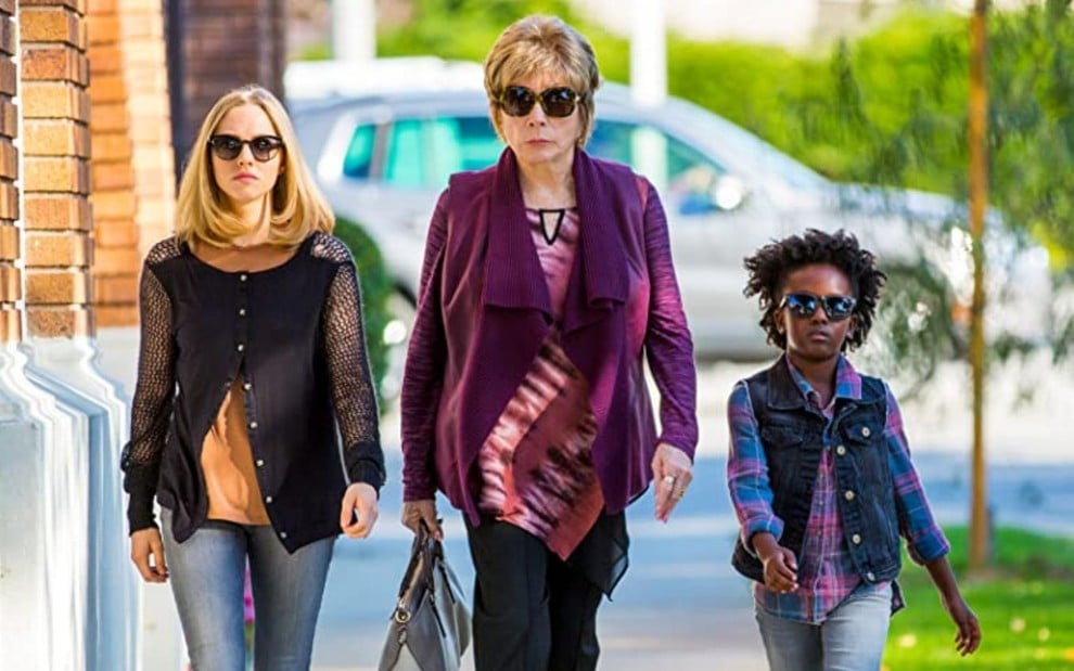 Amanda Seyfried, Shirley MacLaine e AnnJewel Lee Dixon caminham na rua em cena do filme A Última Palavra (2017)