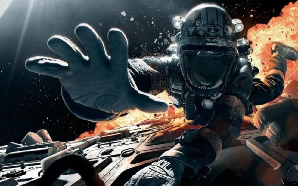 Personagem com roupa de astronauta estende a mão em direção à câmera, com explosão ao fundo, em cena da série The Expanse