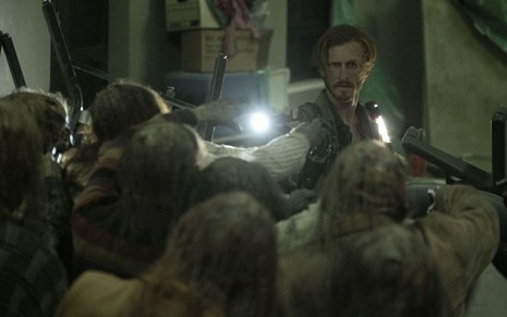 O ator Austin Amelio, caracterizado como Dwight, segura uma lanterna e confronta zumbis em cena de Fear the Walking Dead