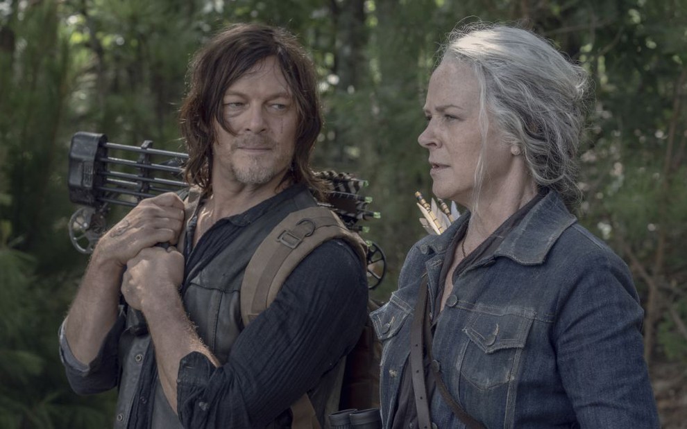No meio de uma floresta, Norman Reedus olha para Melissa McBride em cena de The Walking Dead
