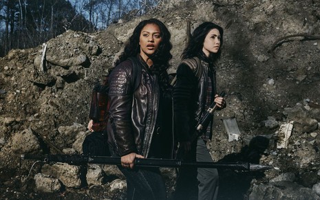 Em meio a uma pilha de entulho e rochas, as atrizes Aliyah Royale e Alexa Mansour fazem carão para divulgar The Walking Dead: World Beyond