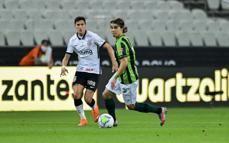 Jogador do América-MG e jogador do Corinthians disputam bola na Neo Química Arena, em São Paulo