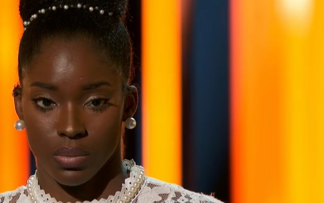 Rosto de Funke Lagoke, participante do American Idol, momentos anets de desmaiar no palco do programa