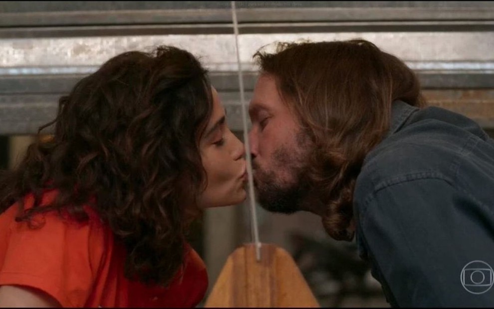 Érica (Nanda Costa) e Davi (Vladimir Brichta) se beijam através de proteção de acrílico na novela Amor de Mãe