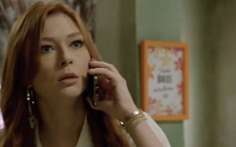 Em cena de Amor Sem Igual, a personagem Poderosa (Day Mesquista) fala ao celular assustada
