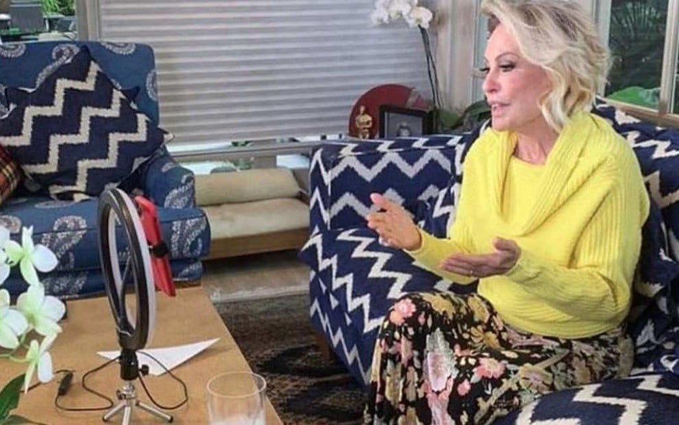 Ana Maria Braga gravando vídeos pelo celular em sua casa