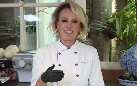 Imagem de Ana Maria Braga com roupa de chef de cozinha e luvas pretas