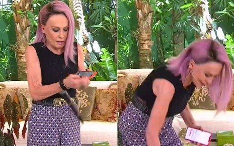 Ana Maria Braga de cabelo lilás, blusa preta, tentando equilibrar microfone e celular nas mãos
