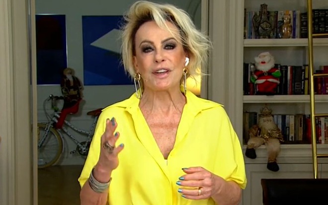 Ana Maria Braga de blusa amarela, decotada, no estúdio em sua casa