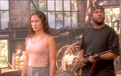 Jennifer Lopez assustada e Ice Cube armado em cena de Anaconda (1997)