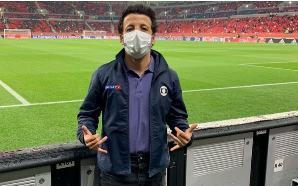 André Hernan com máscara e jaqueta da Globo no estádio no Qatar