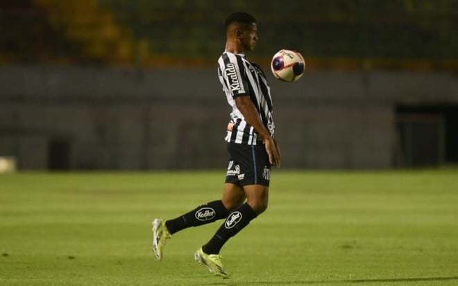 O jogador do Santos Ângelo em lance no campo vestido com o uniforme do time nas cores preto e branco