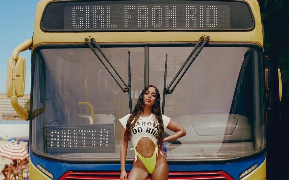 Anitta posa em frente a um ônibus, em cima de uma cadeira de plástico para a capa do single Girl From Rio
