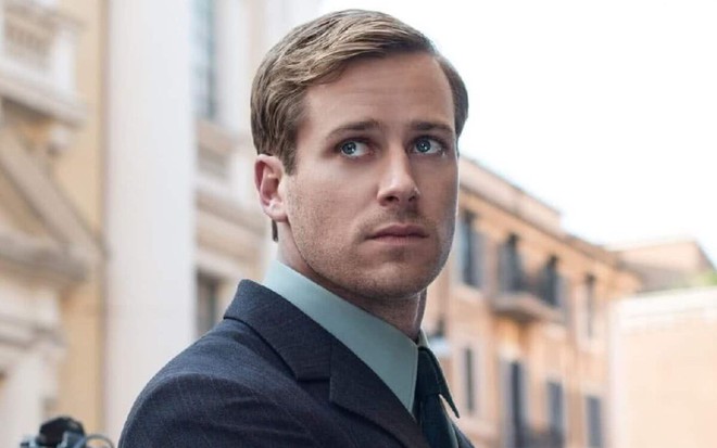 Armie Hammer de cabelo penteado de lado, terno e gravata, figurino de O Agente da U.N.C.L.E