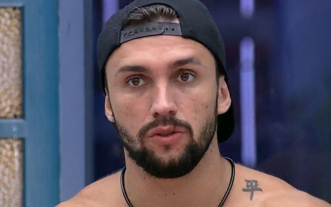 Rosto de Arthur Picoli de boné durante conversa dentro da casa do BBB21