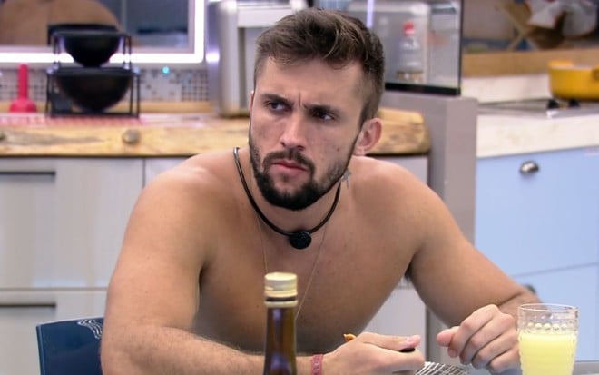 Arthur Picoli com olhar desconfiado durante conversa na cozinha do BBB21