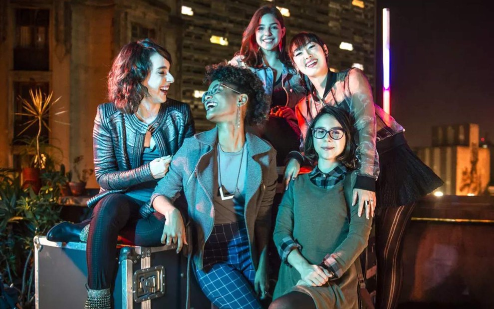 As atrizes Gabriela Medvedovski, Heslaine Vieira, Manoela Aliperti, Ana Hikari e Daphne Bozaski juntas em foto noturna, sorrindo