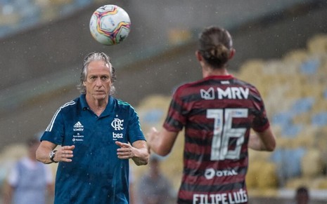 O técnico Jorge Jesus joga uma bola para o lateral Filipe Luís, do Flamengo
