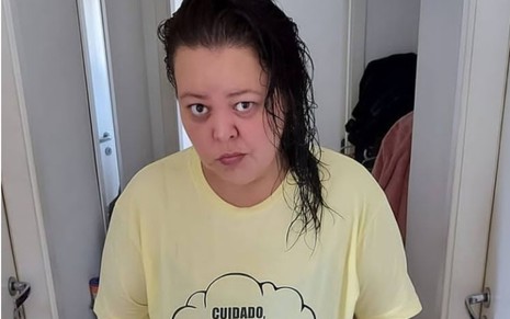 Hélady Araújo de cabelo molhado jogado para cima do ombro esquerdo com camiseta amarela