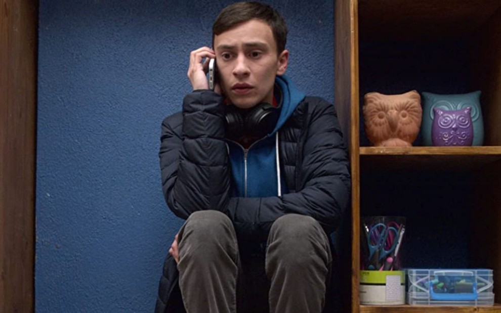 Keir Gilchrist fala ao telefone agachado no chão em cena da segunda temporada de Atypical