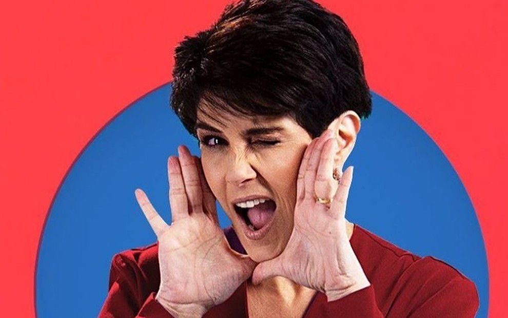 A apresentadora Mariana Godoy posa em cenário colorido e com as mãos no rosto em foto de campanha de divulgação de seu novo programa na Band