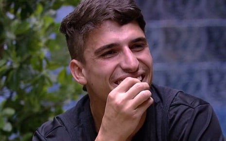 Felipe Prior sorri na sala do Big Brother Brasil, a Globo