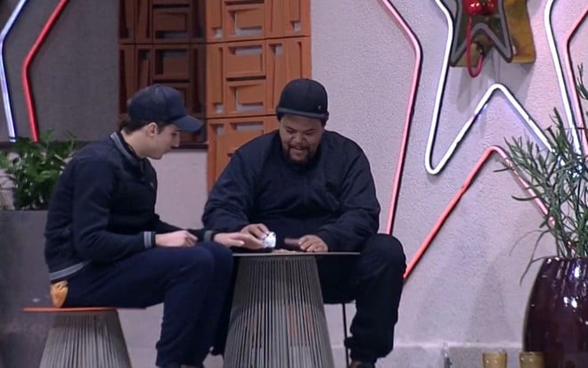 Imagem de Felipe Prior e Babu Santana vestidos de preto ao lado do Big Fone no BBB20