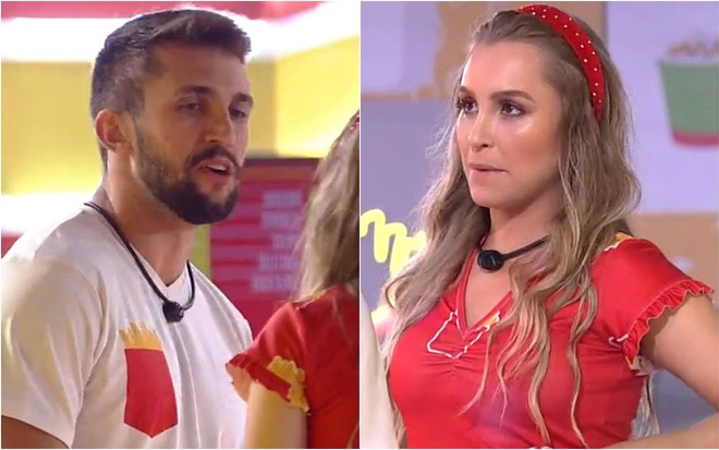 Arthur olha para Carla, ele usa camiseta branca com detalhe vermelho; ela usa camiseta vermelha e lenço vermelho na cabeça