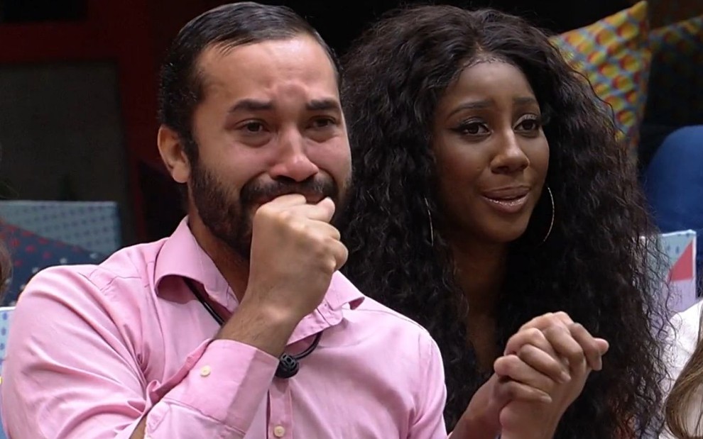Gilberto chora enquanto segura a mão de Camilla no sofá do BBB21; ele foi eliminado do reality da Globo
