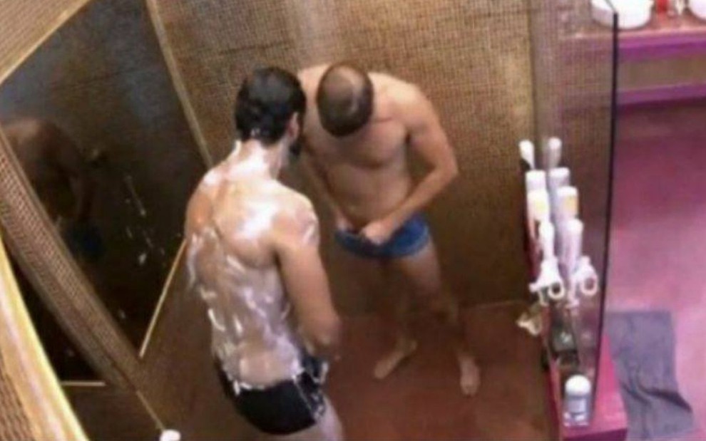 Rodolffo confere o machucado no pênis de Caio enquanto os dois tomam banho no BBB21