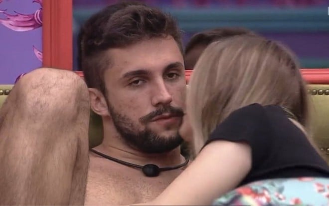 Imagem de Arthur Picoli (à esq.) e Carla Diaz deitados na cama de casal do quarto colorido no BBB21