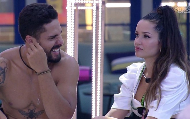 Imagem de Arcrebiano Araújo, sem camisa, conversando com Juliette Freire durante festa do BBB21